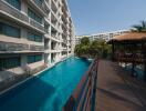 Luxurious residential building with a large swimming pool and ample balconies