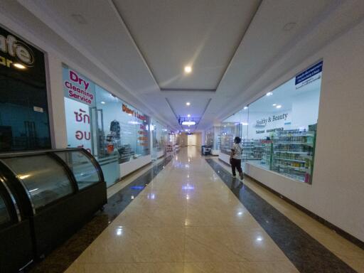 Interior of a commercial building with various shops and illuminated corridor