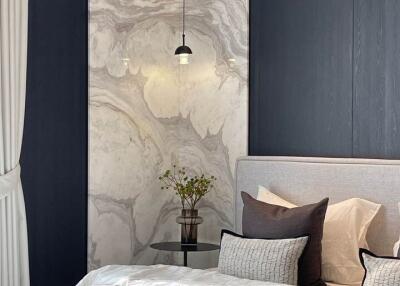 Elegant bedroom with marbled wall panel and sophisticated decor