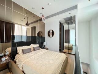 Modern bedroom with reflective decor and ambient lighting