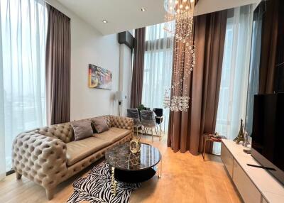 Elegant living room with modern furnishings, including a tufted sofa and stylish glass coffee table