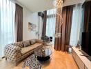 Elegant living room with modern furnishings, including a tufted sofa and stylish glass coffee table