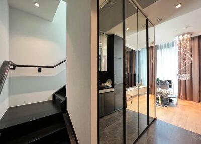 Modern entrance hall with reflective surfaces and elegant staircase