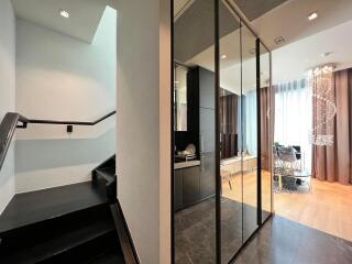 Modern entrance hall with reflective surfaces and elegant staircase
