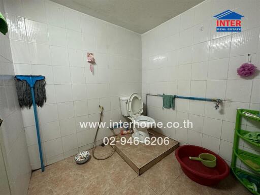 Spacious tiled bathroom with basic fixtures