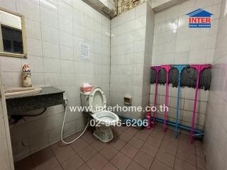 Compact bathroom with essential amenities and multiple cleaning supplies