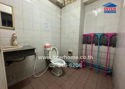 Compact bathroom with essential amenities and multiple cleaning supplies