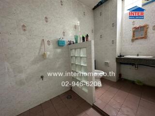 Spacious bathroom with white tiles and ample shelving