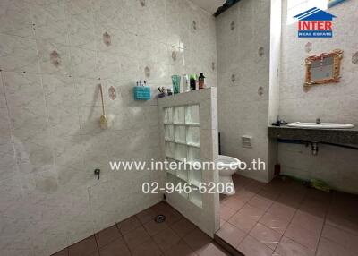 Spacious bathroom with white tiles and ample shelving