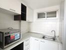 Compact and modern kitchen with white cabinets and built-in appliances