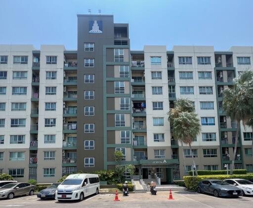 Modern multi-story residential building with parked vehicles