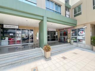 Entrance of a commercial residential building with visible ground floor shops