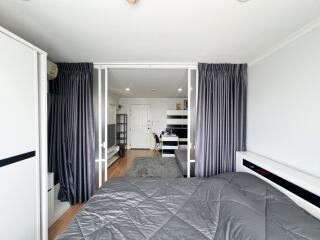 Spacious bedroom with integrated living area leading to a kitchen