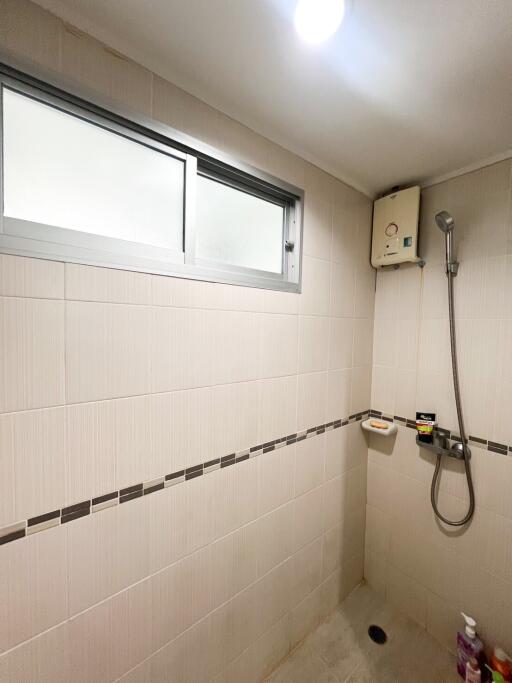 Modern tiled bathroom with shower and window