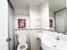 Modern bathroom interior with clean white fixtures and decorative artwork