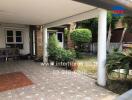 Covered carport area of a home with paved flooring and garden view