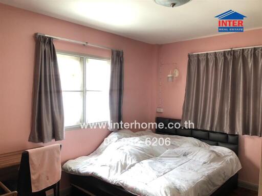 Spacious bedroom with pink walls and large windows
