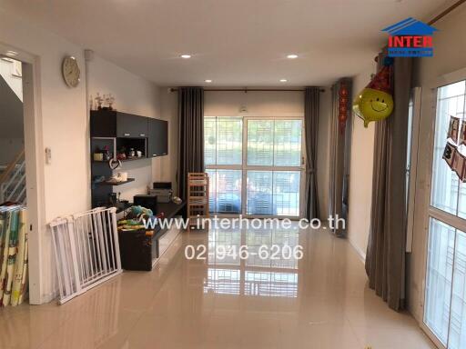 Spacious and well-lit living room with kitchenette
