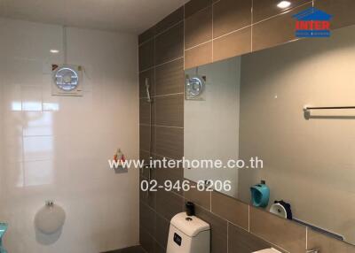 Modern bathroom with beige tiles and essential amenities