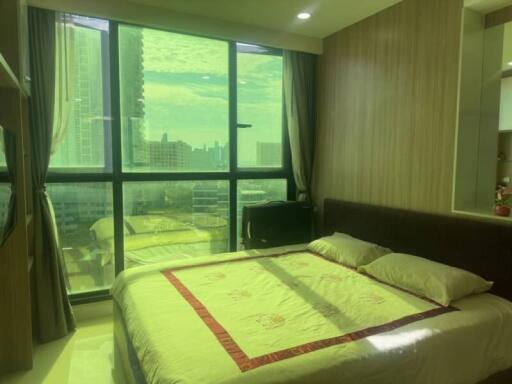 Spacious bedroom with large window overlooking the city