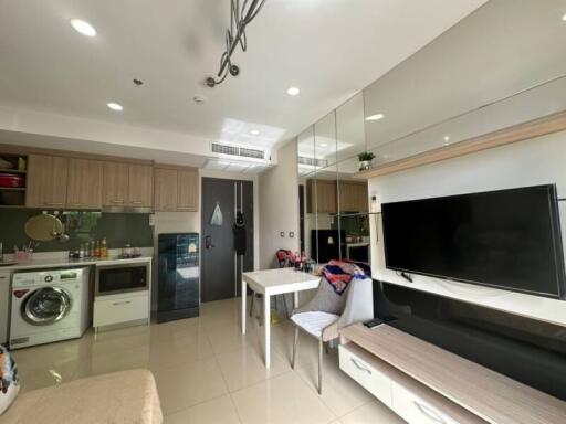 Compact and modern multi-functional living space with integrated kitchen, laundry, and entertainment area