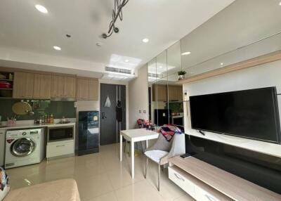 Compact and modern multi-functional living space with integrated kitchen, laundry, and entertainment area