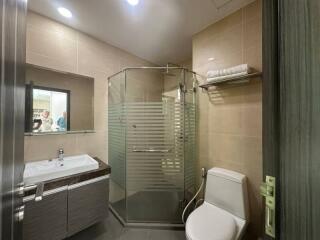 Modern bathroom with glass shower enclosure and well-lit vanity area