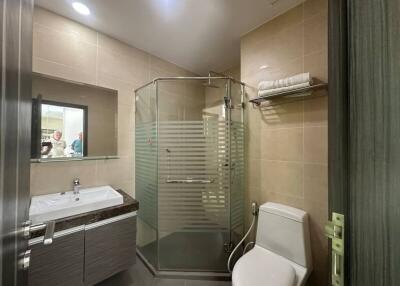 Modern bathroom with glass shower enclosure and well-lit vanity area