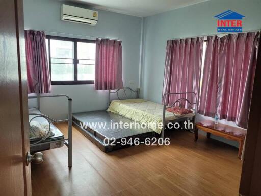 Spacious bedroom with twin beds and air conditioning unit