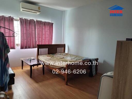 Spacious bedroom with wooden furniture and air conditioning