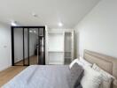 Modern bedroom with large bed and sliding glass door wardrobe