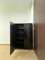 Empty room interior with an open black cabinet