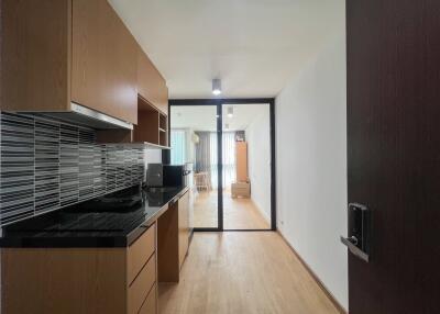 Modern kitchen leading to a well-lit living room