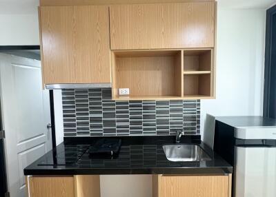 Compact modern kitchen with wooden cabinets and black countertop