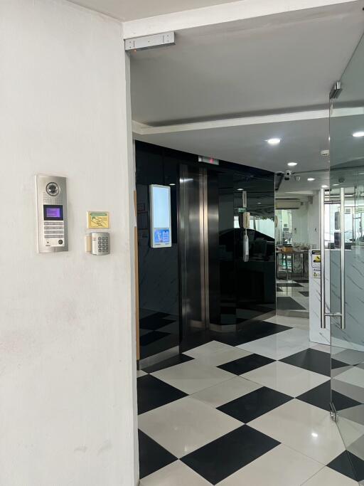 Modern building lobby with checkered floor and glass doors