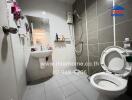 Modern bathroom with full wall tiling and essential fixtures