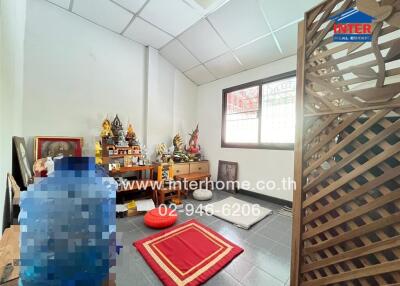 Spacious living room with a cultural display, including a shrine and seating area