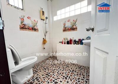 Spacious tiled bathroom with window and multiple hygiene products