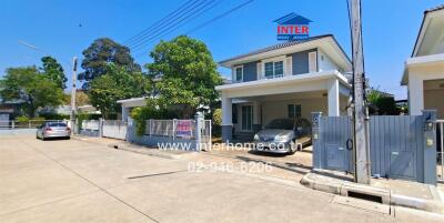 Modern two-story house with gated driveway and blue sky