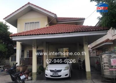 Front view of a two-story residential house with carport