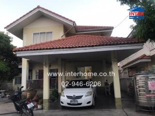 Front view of a two-story residential house with carport