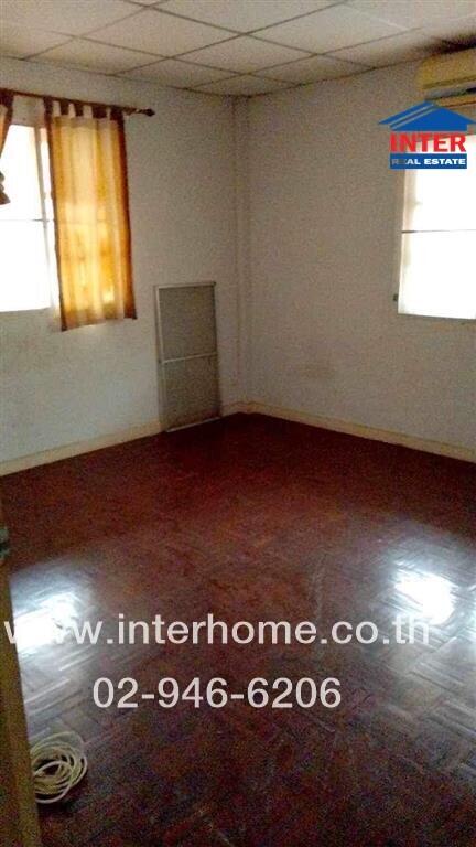 Spacious empty bedroom with parquet flooring and single window