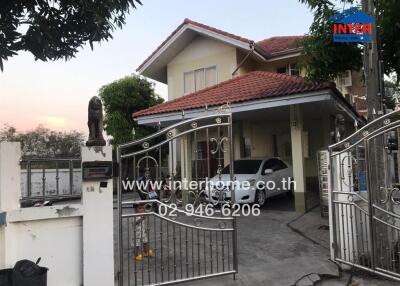 Exterior view of a two-story residential house with gated entrance