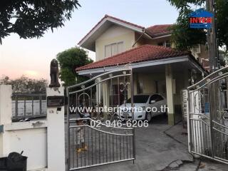 Exterior view of a two-story residential house with gated entrance