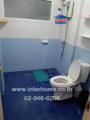 Small bathroom with white and blue tiles and essential fixtures