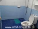 Small bathroom with white and blue tiles and essential fixtures