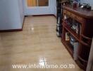 Spacious living room with tiled flooring and traditional wooden furniture