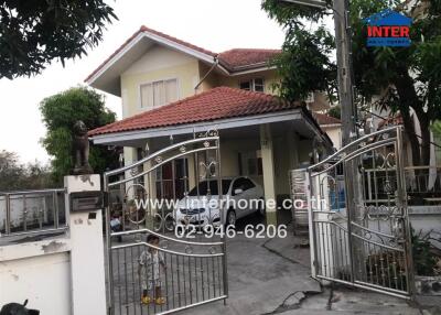Two-story house with gate and carport