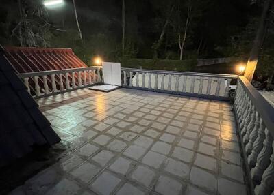 Night view of a spacious balcony with tiled floor and forest in the background
