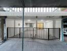 Spacious covered garage area with tiled flooring and secure gate